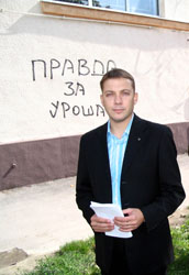 Aleksandar Marton ispred fasade sa grafitom
